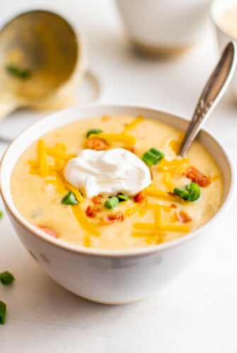 A bowl of instant pot potato soup with sour cream and other toppings.