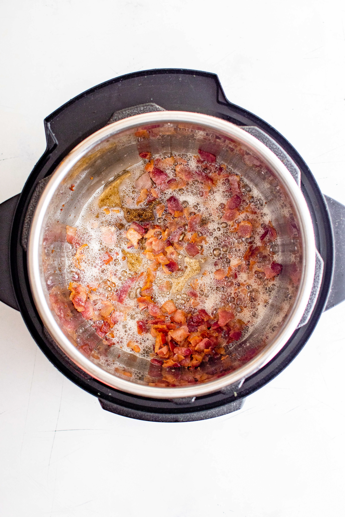 Crispy chopped bacon cooking in an instant pot.