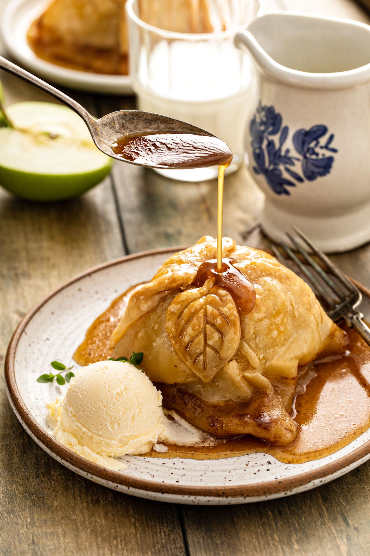 A baked apple in pastry with cinnamon sauce and a scoop of vanilla ice cream.