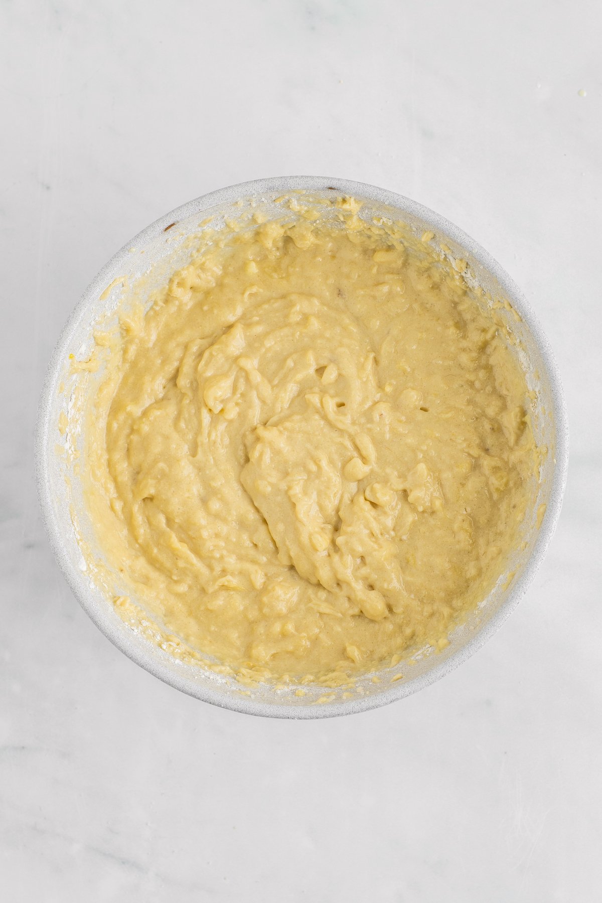 Overhead shot of a white bowl of quick bread batter.
