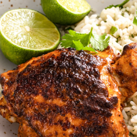 Pollo asado on a bed of cilantro lime rice on a plate.