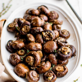 A platter of whole roasted cremini mushrooms.