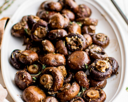 A platter of whole roasted cremini mushrooms.