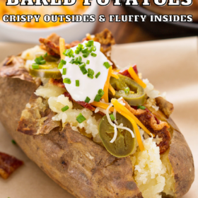 A baked potato on a plate with all the toppings loaded inside.