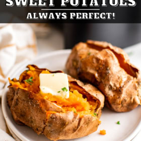 Two sweet potatoes on a plate with one sliced in half with butter inside.