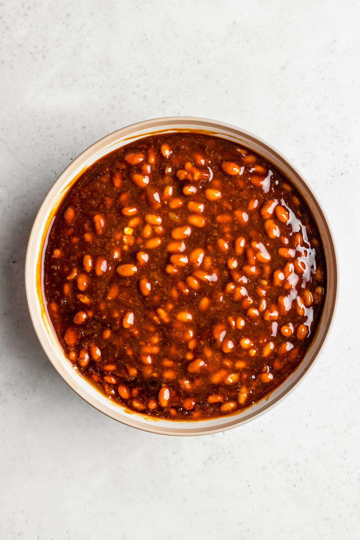 A bowl of dark, saucy baked beans.