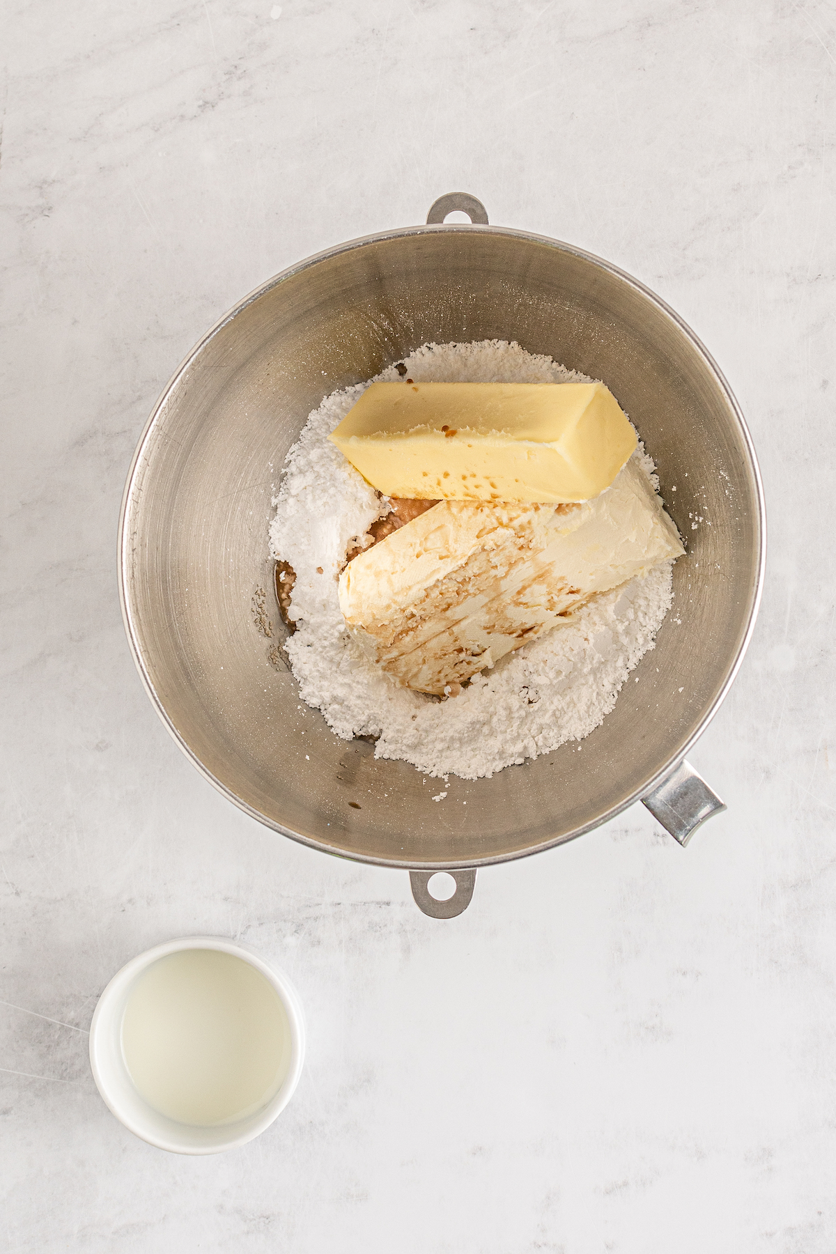 Butter, powdered sugar, and other frosting ingredients in a mixing bowl.