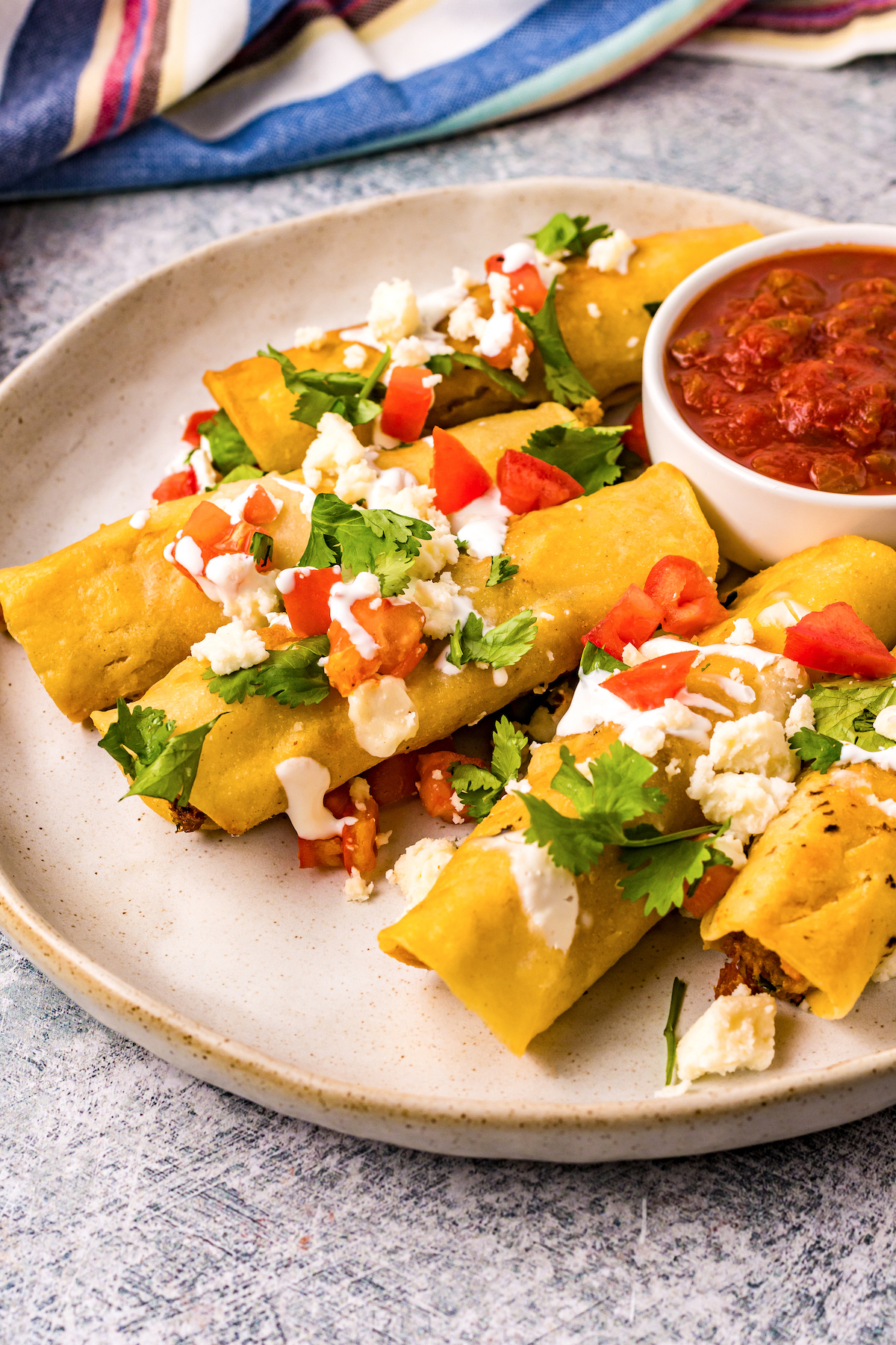 Homemade taquitos with salsa on the side.