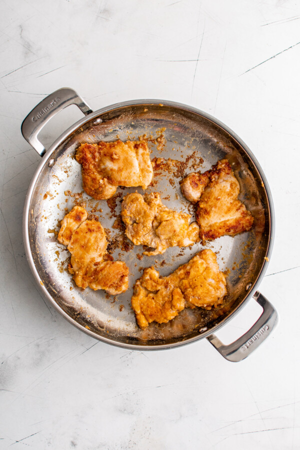 Crispy dredged chicken in the pan.