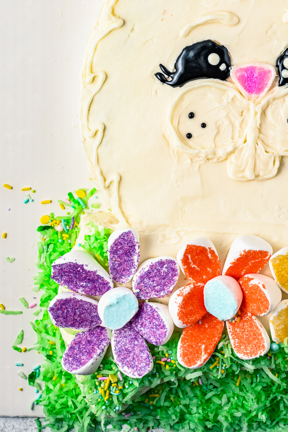 A cute bunny cake with marshmallow and coconut decorations.