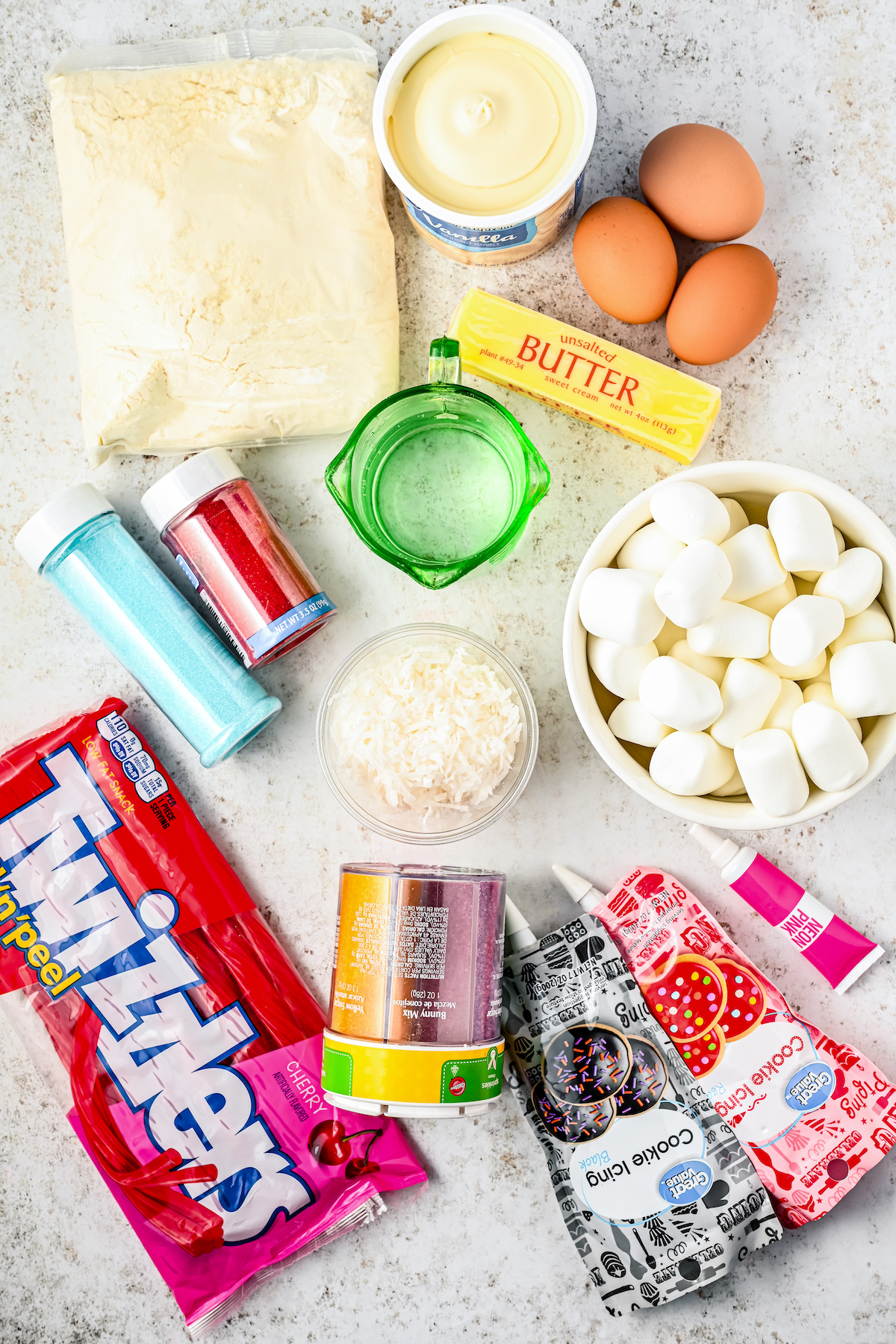 Cake mix, eggs, and other cake ingredients, along with marshmallows, icing, colored sugar, and candy.