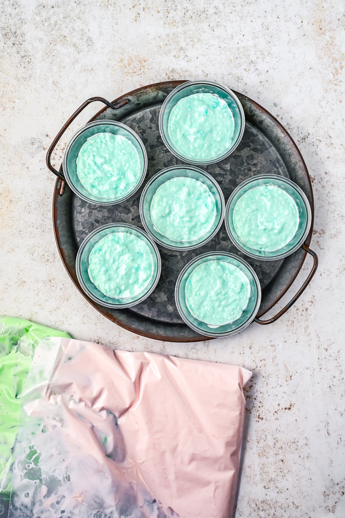 Adding creamy blue Jello to cups.