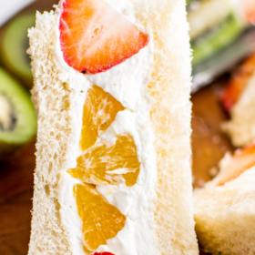 A slice of Japanese fruit sandwich with sliced strawberries and oranges.
