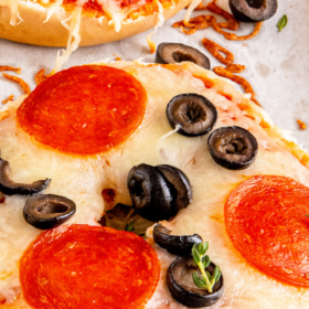 Pizza bagels with pepperoni and olives.