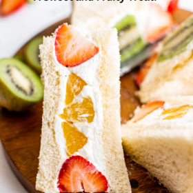 A slice of fruit sandwich with orange and strawberries inside.