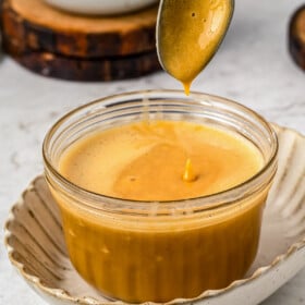Homemade dulce de leche in a glass container.