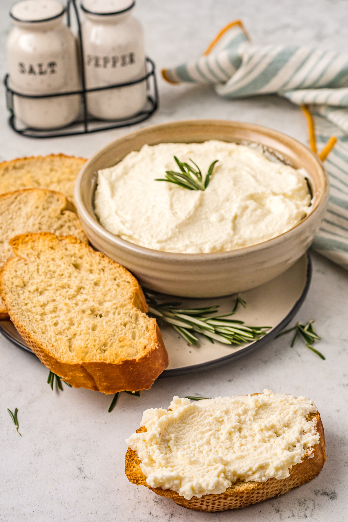 Side photo of homemade ricotta with toasted baguette slices.