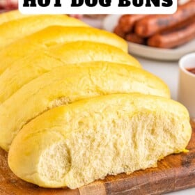 Hot dog buns on a cutting board.