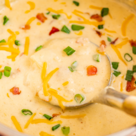 Potato soup in an instant pot with a ladle scooping up a serving.