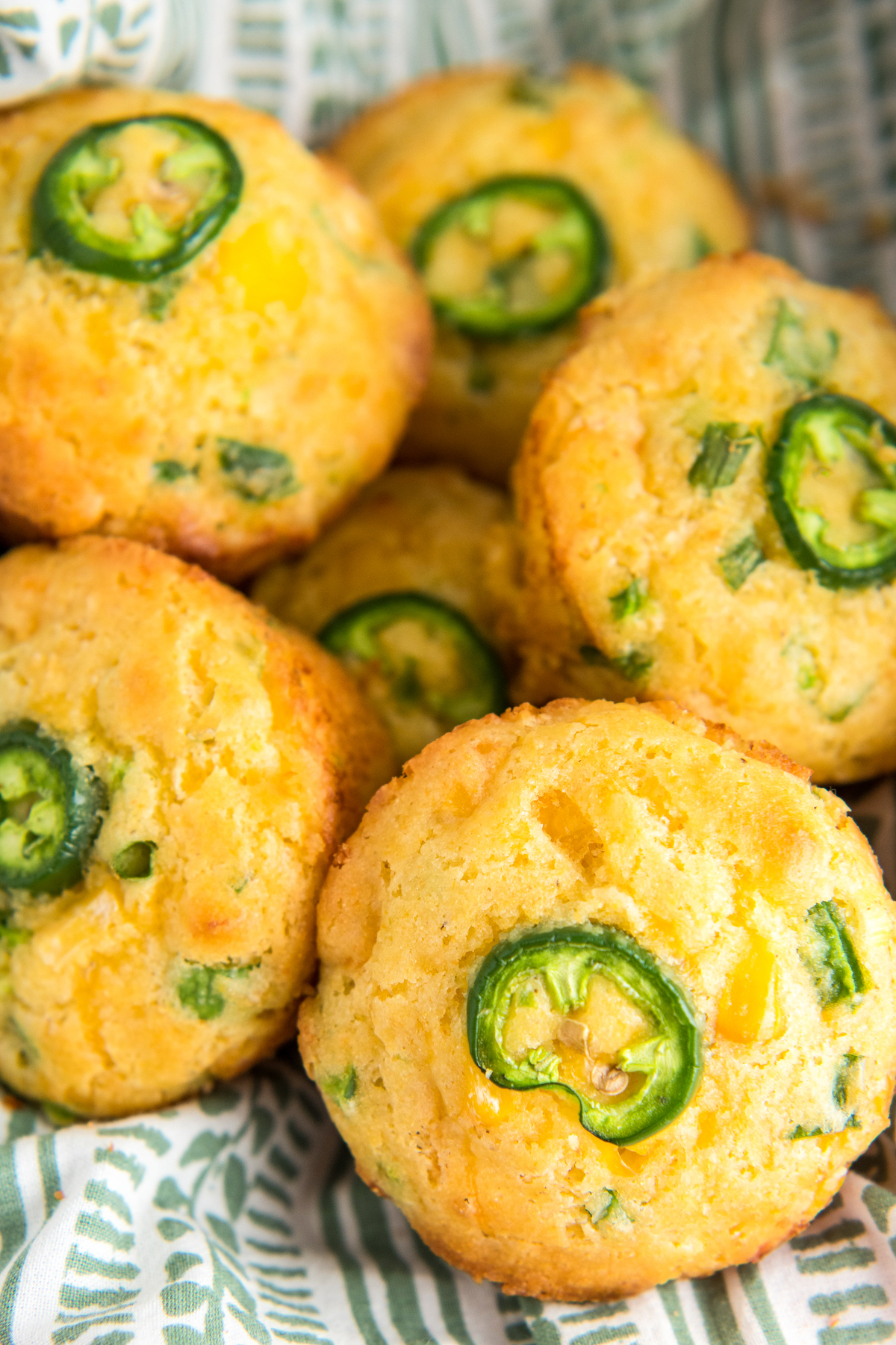 Cornbread muffins piled into a basket lined with a clean tea towel.