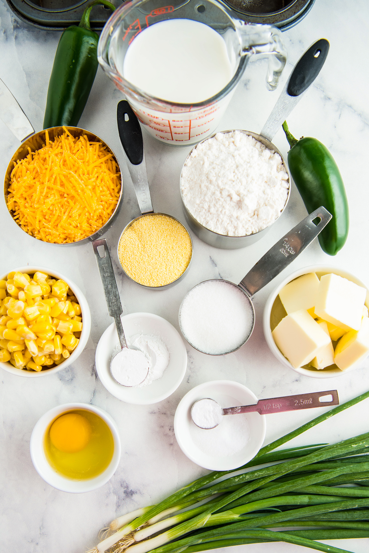 The ingredients for cornbread muffins, measured into small dishes and arranged on a work surface.