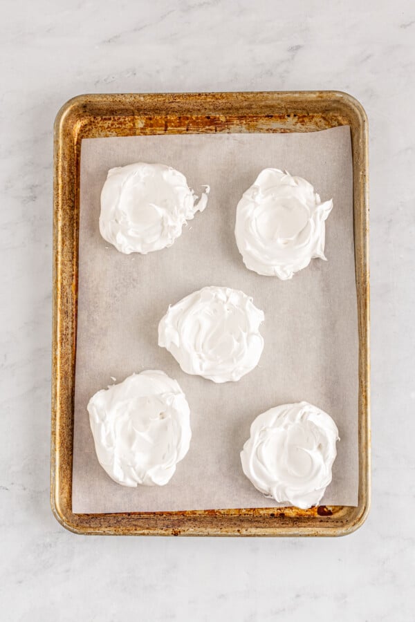 Making a well in the center of each meringue cookie before baking.