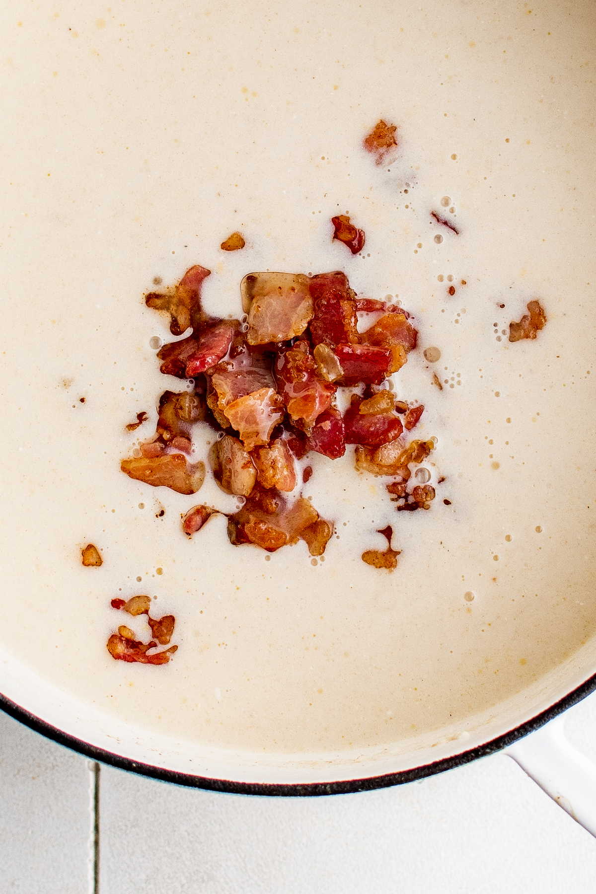Crispy bacon added to a soup pot.