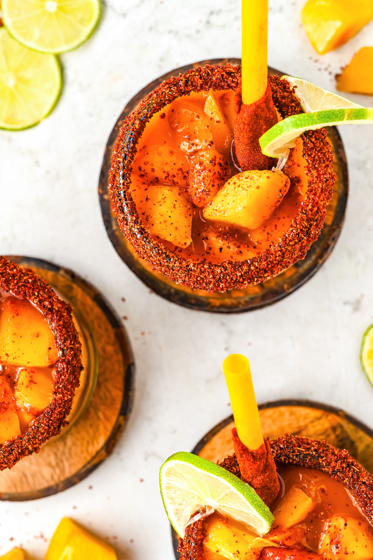 Overhead of mangonada drink in swerving glasses.