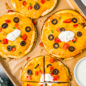 Copycat mexican pizzas with sour cream and olives on top.