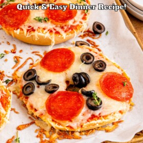 Pizza bagels on a baking sheet lined with parchment paper.
