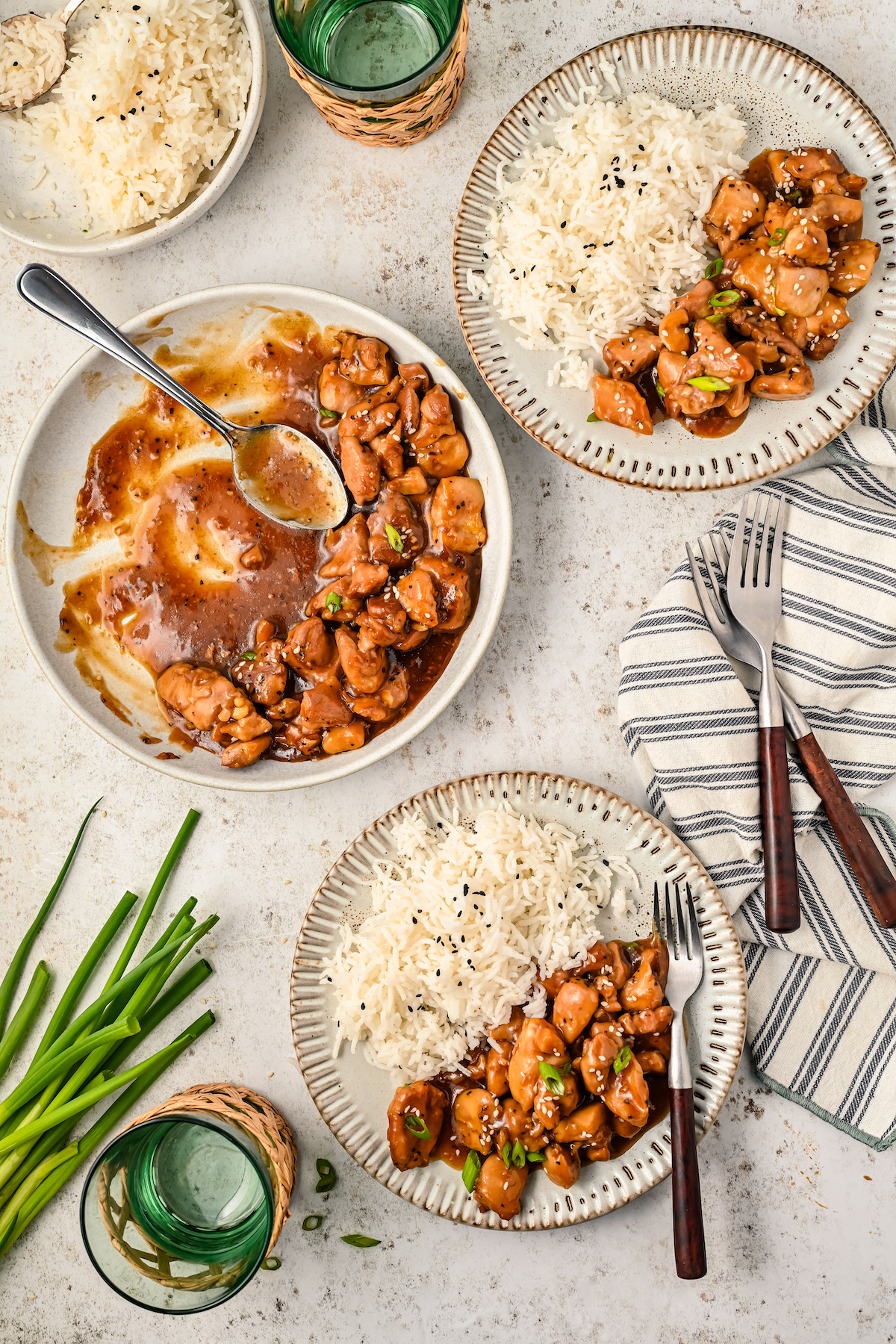 Two bowls with bourbon chicken and a side of white rice. 