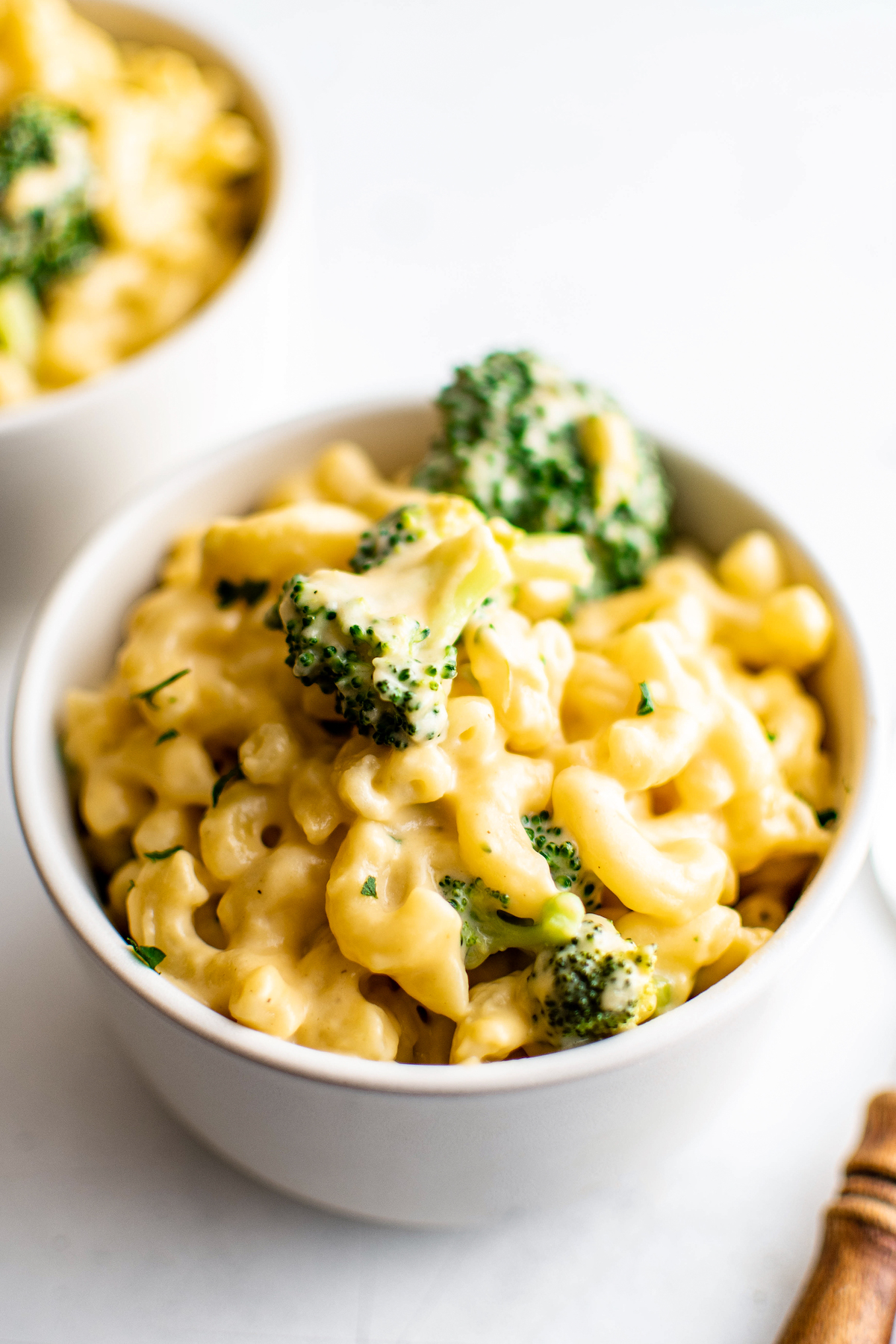 Macaroni and cheese with broccoli in small, white bowls.