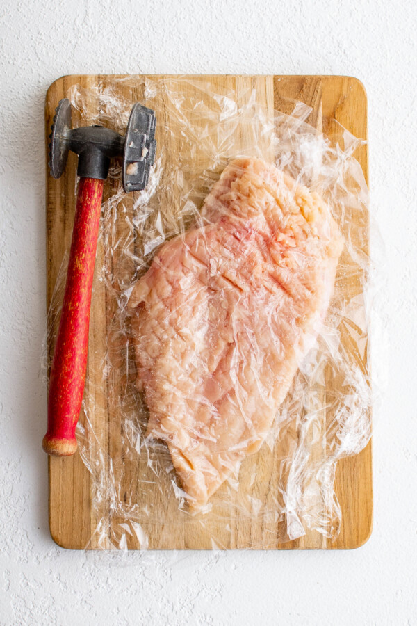 Flattening the chicken with a meat mallet.