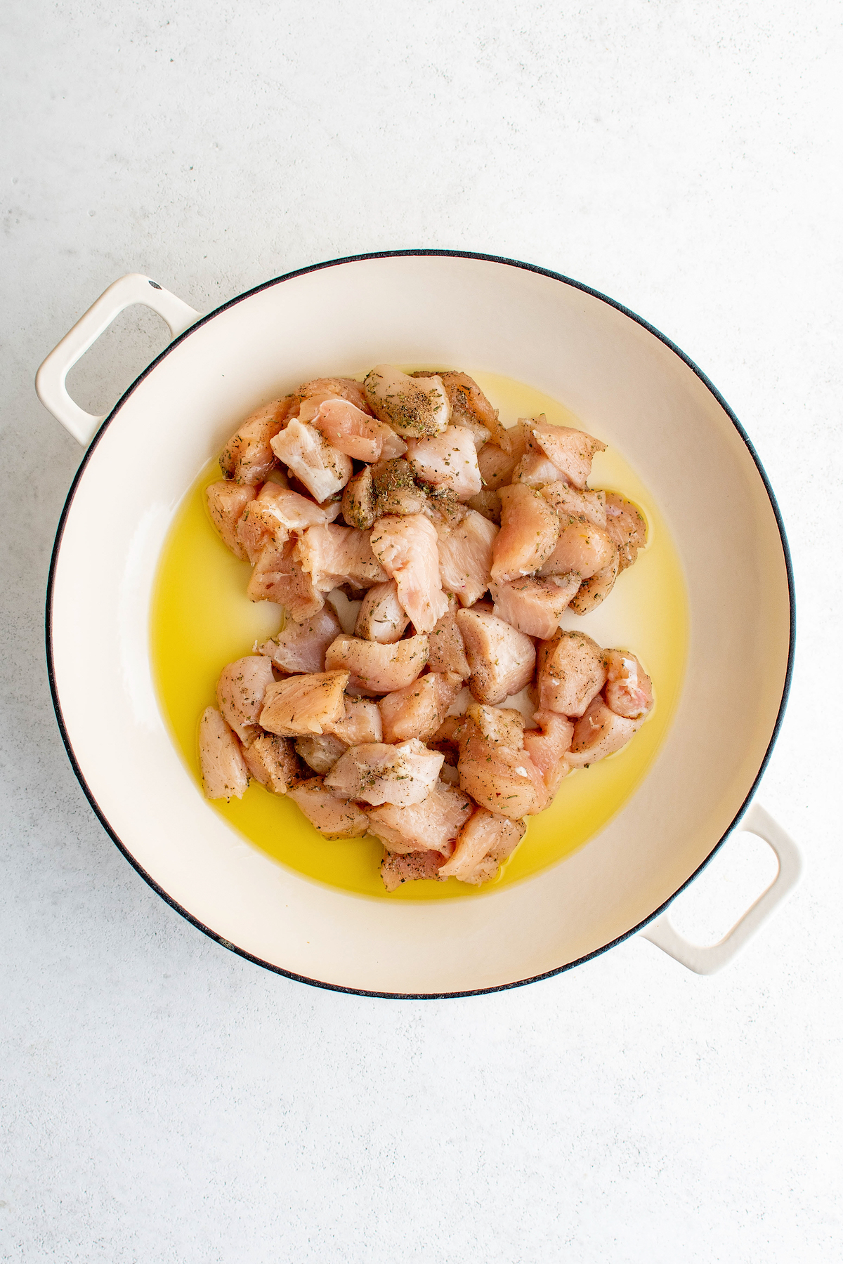 Adding the chicken to the pan.