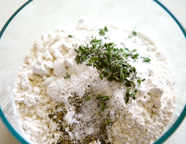 Flour and seasonings in a glass bowl.