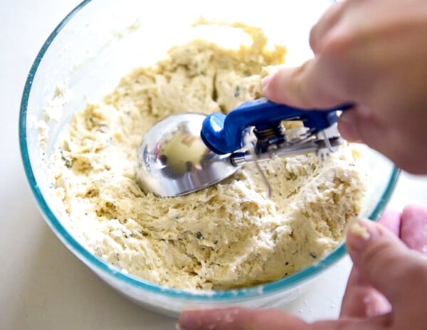 A cookie scoop scooping dumplings.