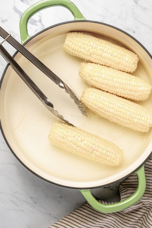 Corn being boiled in a pot.