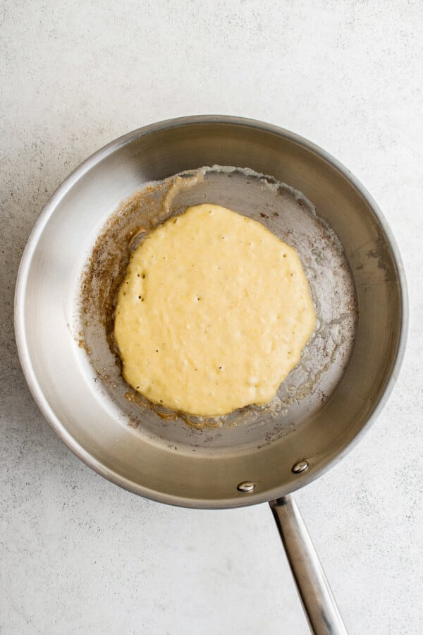 A skillet with a hoe cake cooking in it.