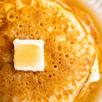 Cornmeal pancakes with butter and syrup.