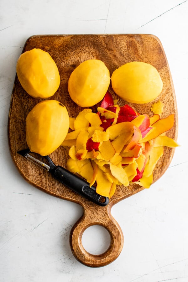 Peeled mangos on a cutting board.
