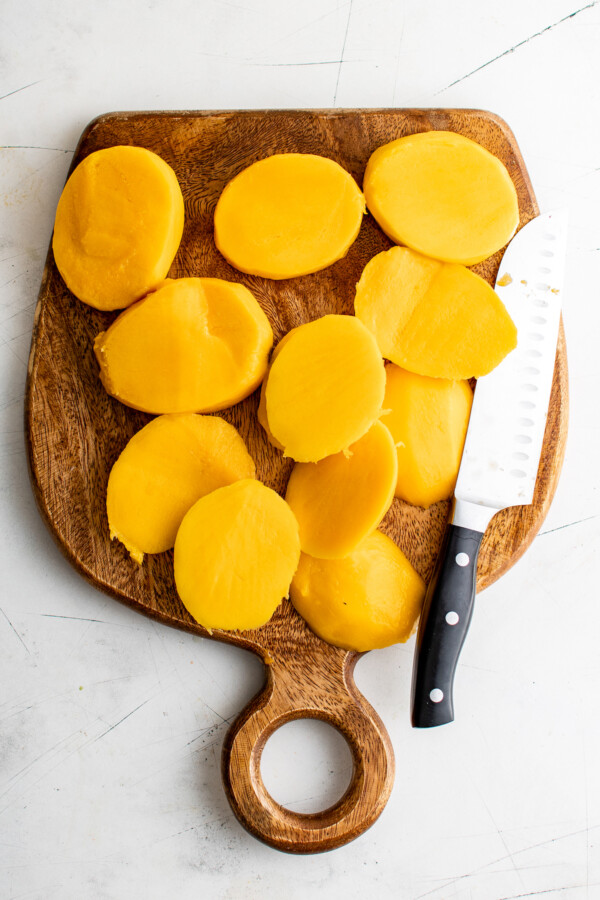 Mango chunks on a cutting board.