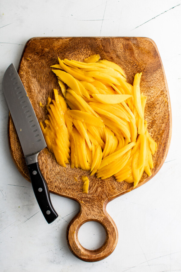 Julienned mango on a cutting board.