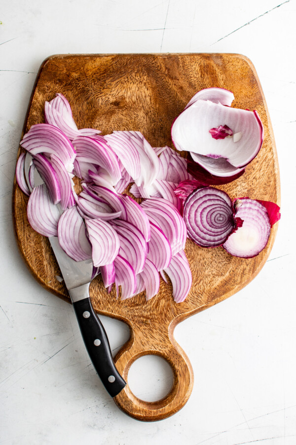 Sliced red onion on a cutting board.