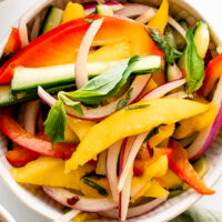 A single serving of mango salad in a small white bowl.