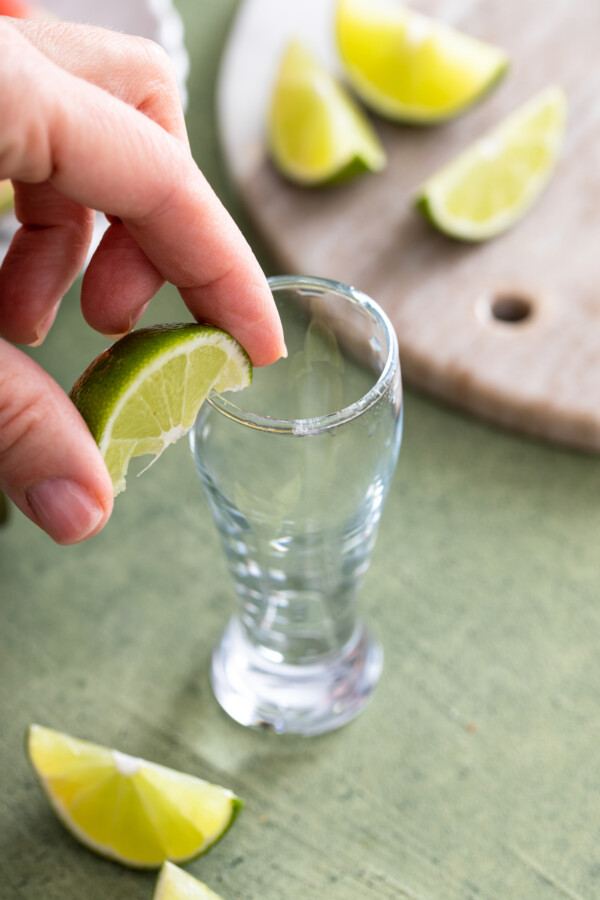 Riming a shot glass with lime.