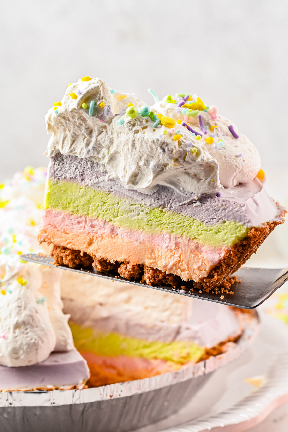 A slice of cheesecake being lifted from a pie dish.