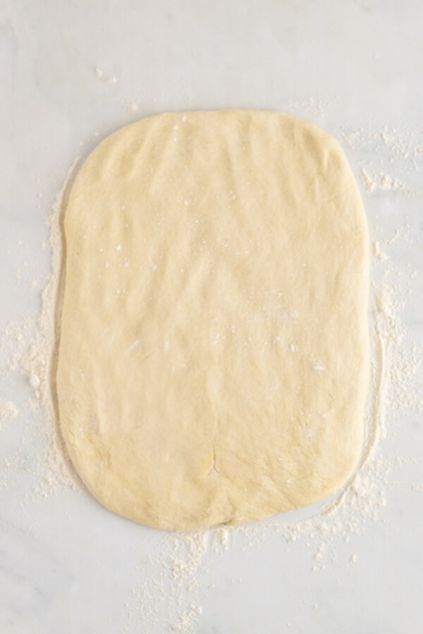 Dough pressed out into a rectangle on a work surface.