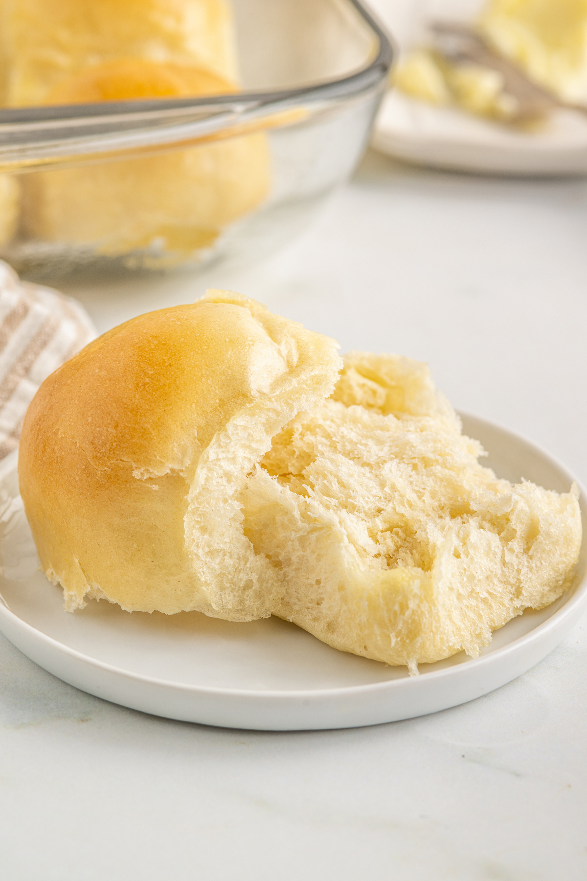 A dinner roll sliced in half to show the texture.