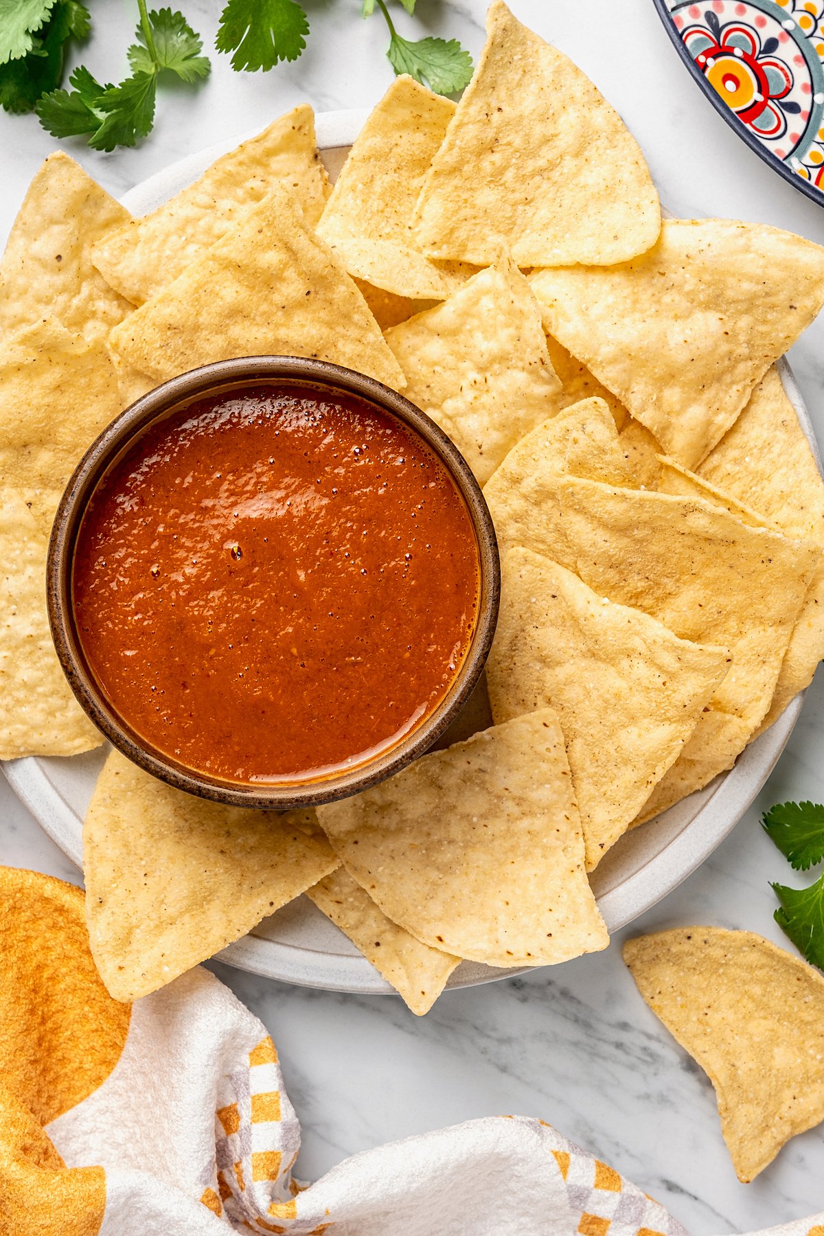 Bowl of guacamole on Mexican comal decorated with tortilla chips