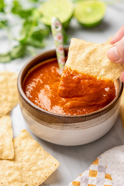 Dipping a corn chip into a bowl of salsa morita.